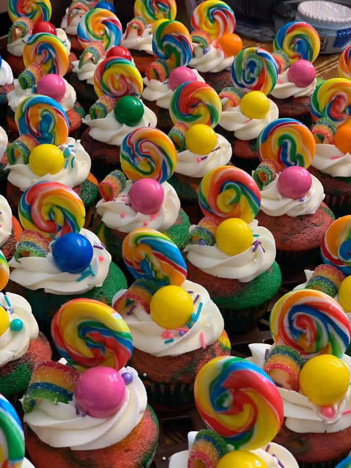 Rainbow swirl lollipop cupcakes with buttercream, gumballs, and sour candy
