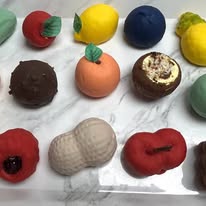 Chocolates and pastries shaped like apples, lemons, oranges, and a peanut